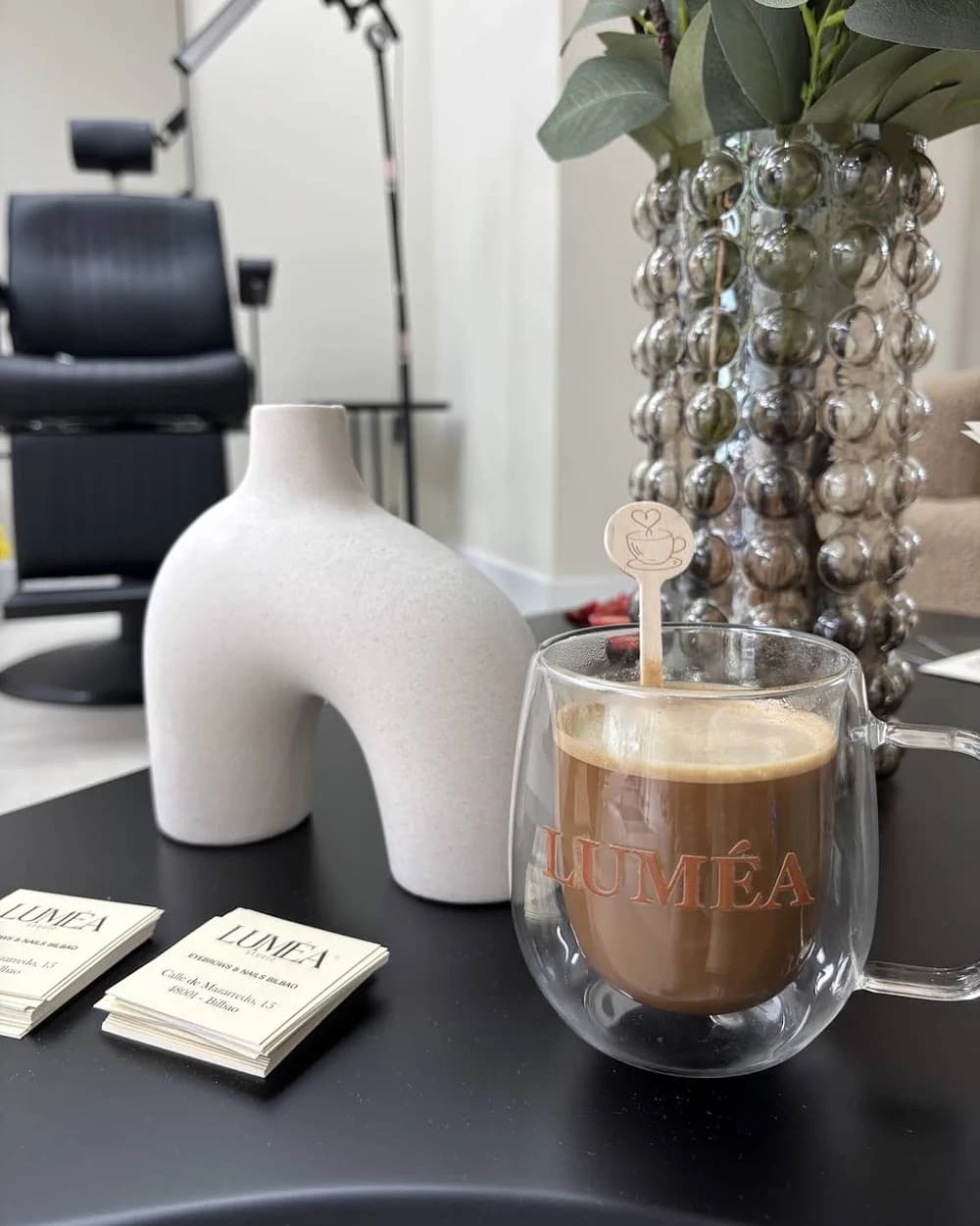 Taza de café con la marca Luméa y tarjetas del estudio